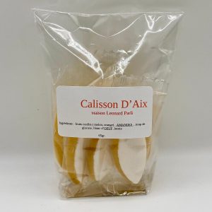 Sachet transparent contenant six calissons ovales, glacés de blanc, présentés côte à côte dans un emballage simple et élégant