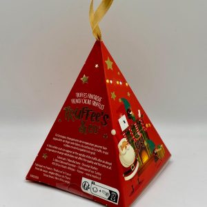 Boîte cadeau pyramidale rouge de truffes décorée d’illustrations festives, représentant des lutins qui décorent un sapin et préparent des cadeaux, avec un petit ruban doré au sommet.